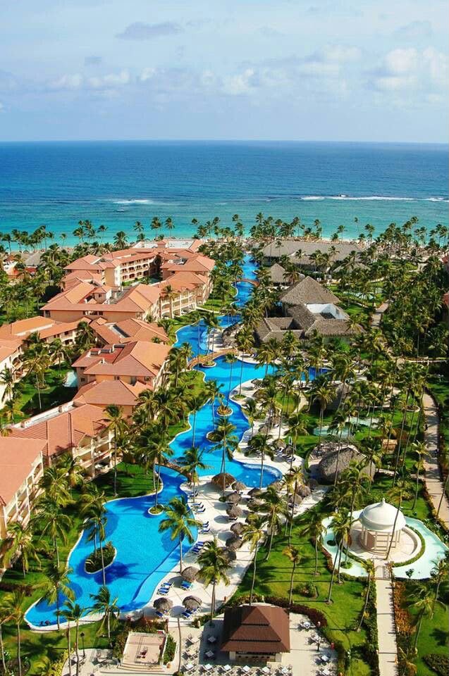 Resort com lagoa de piscina entre palmeiras e o oceano